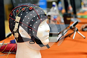 The electroencephalogram EEG head cap with flat metal discs electrodes attached to a white plastic modelÃ¢â¬â¢s head photo